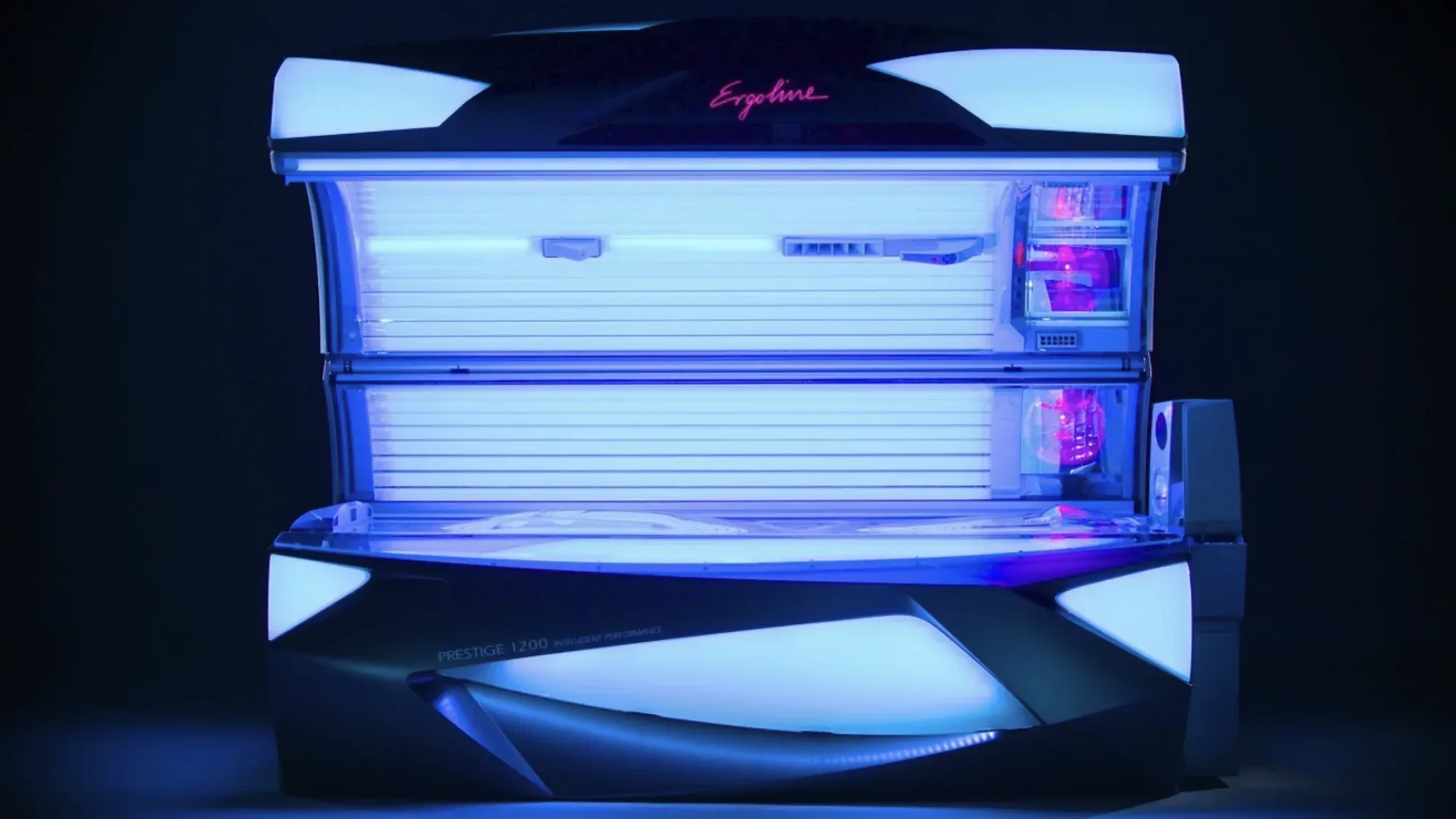 Illuminated Ergoline Prestige 1200 sunbed glowing blue in a dark studio filmed by floating harbour