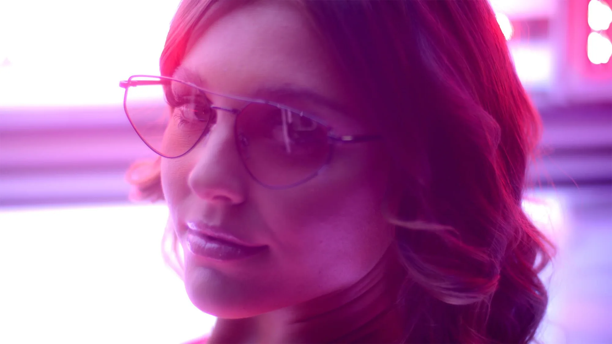A woman wearing glasses looks at the camera in a floating harbour commercial film