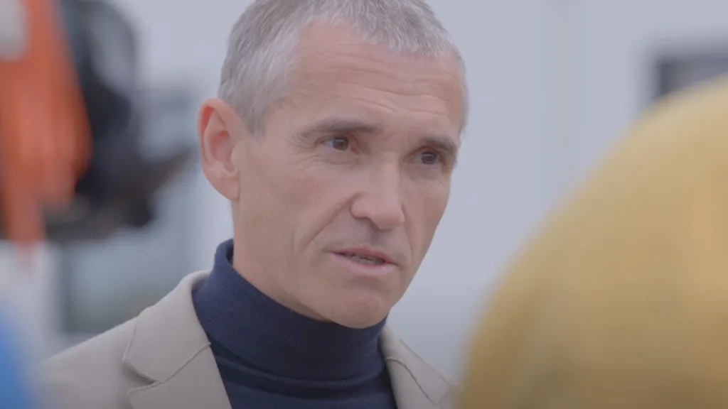 A close-up portrait of Valery Miftakhov, the CEO of ZeroAvia, wearing a beige jacket and a navy turtleneck, filmed as part of a corporate video production in Bristol.