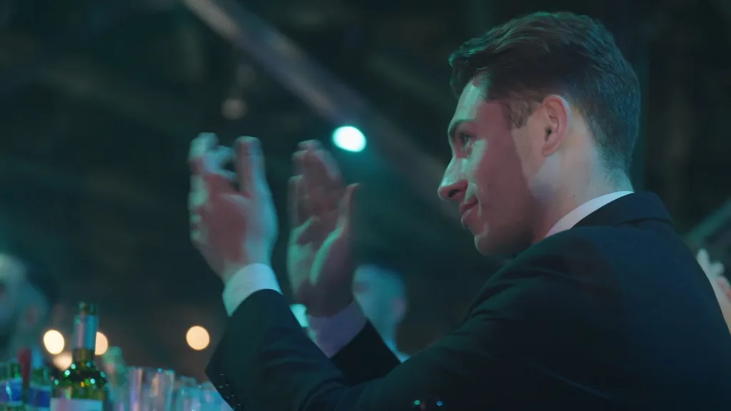 A guest in formalwear applauds during a corporate awards event, captured as part of a FinTech and Accounting Excellence awards film.