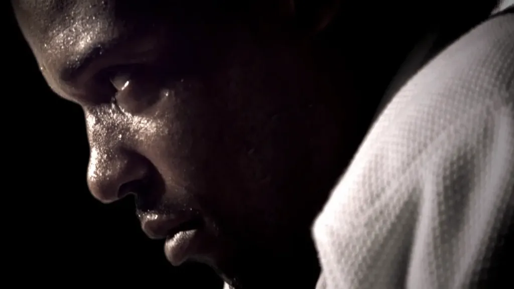 Close up of a sweating judo athlete in a white gi under dramatic lighting