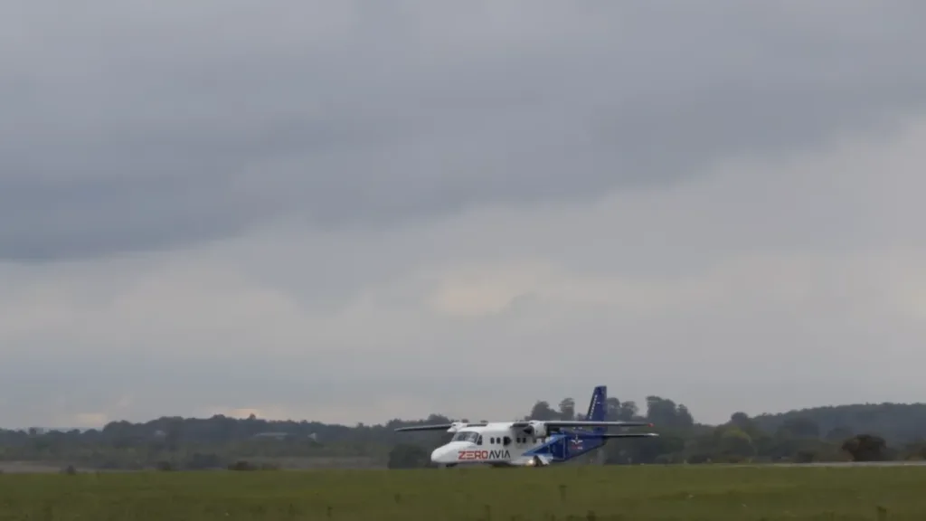 ZeroAvia plane taxiing on a grassy runway with cloudy sky in the background