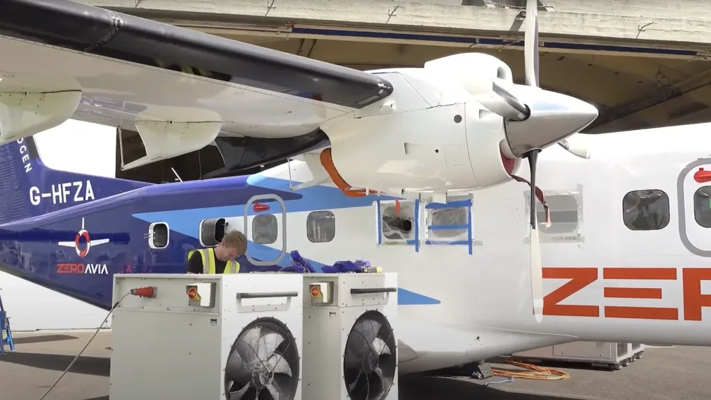 Technician working beside the ZeroAvia Dornier 228 aircraft on the ground during hydrogen-electric testing.