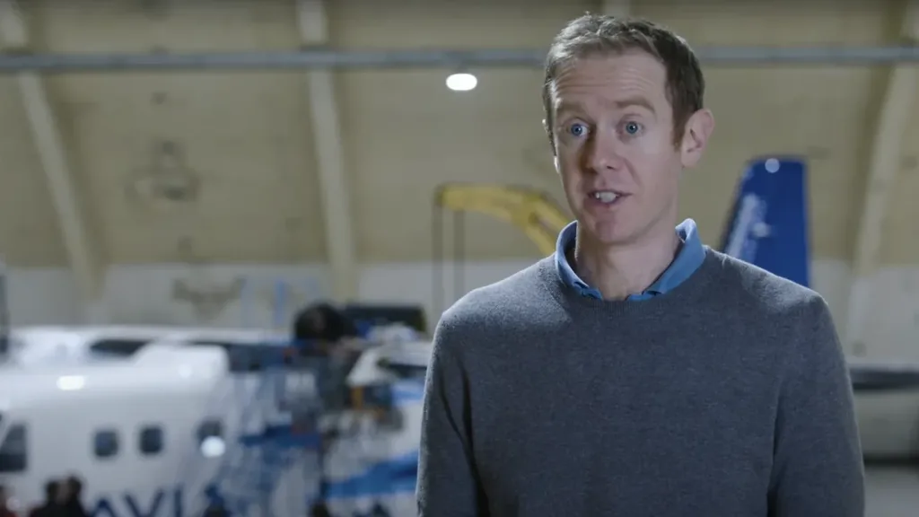 A man speaks during an interview inside a hangar with a ZeroAvia plane behind him