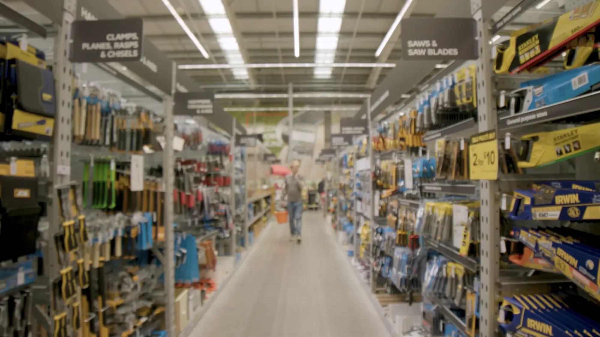 Person walking down a tools aisle in a DIY hardware store.