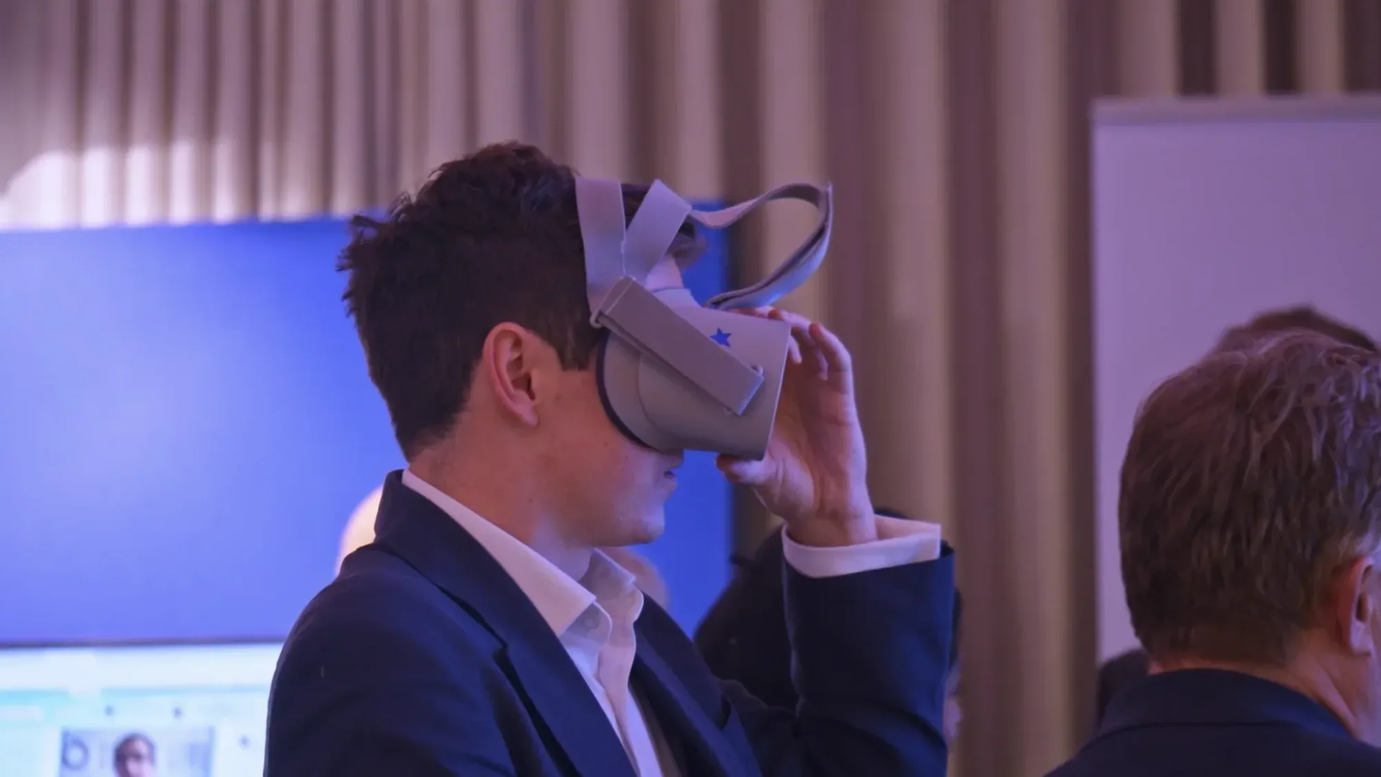 A man in a suit wears a virtual reality headset during the VocTech event