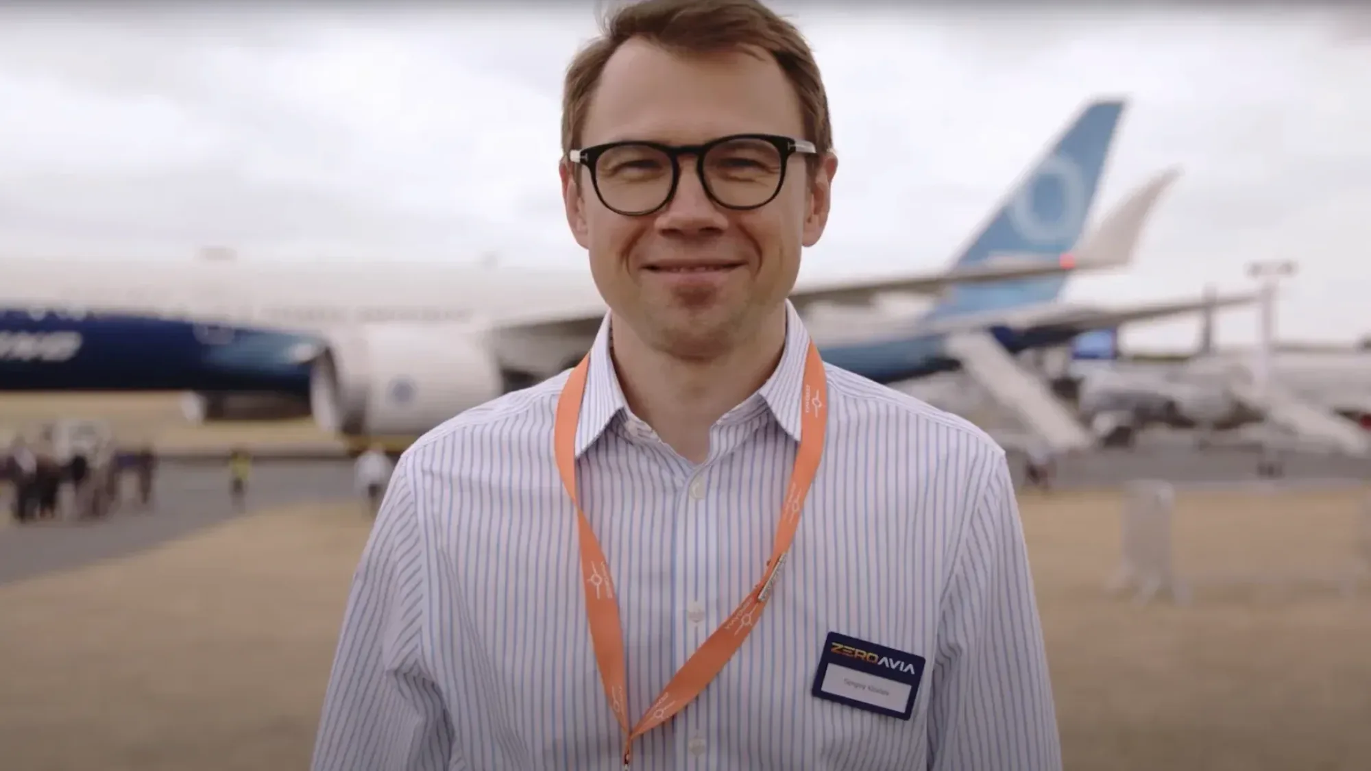 Senior ZeroAvia representative stands in front of aircraft at an outdoor event