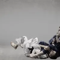 Two judo athletes grapple on the mat in an illustrated style with a grey textured background