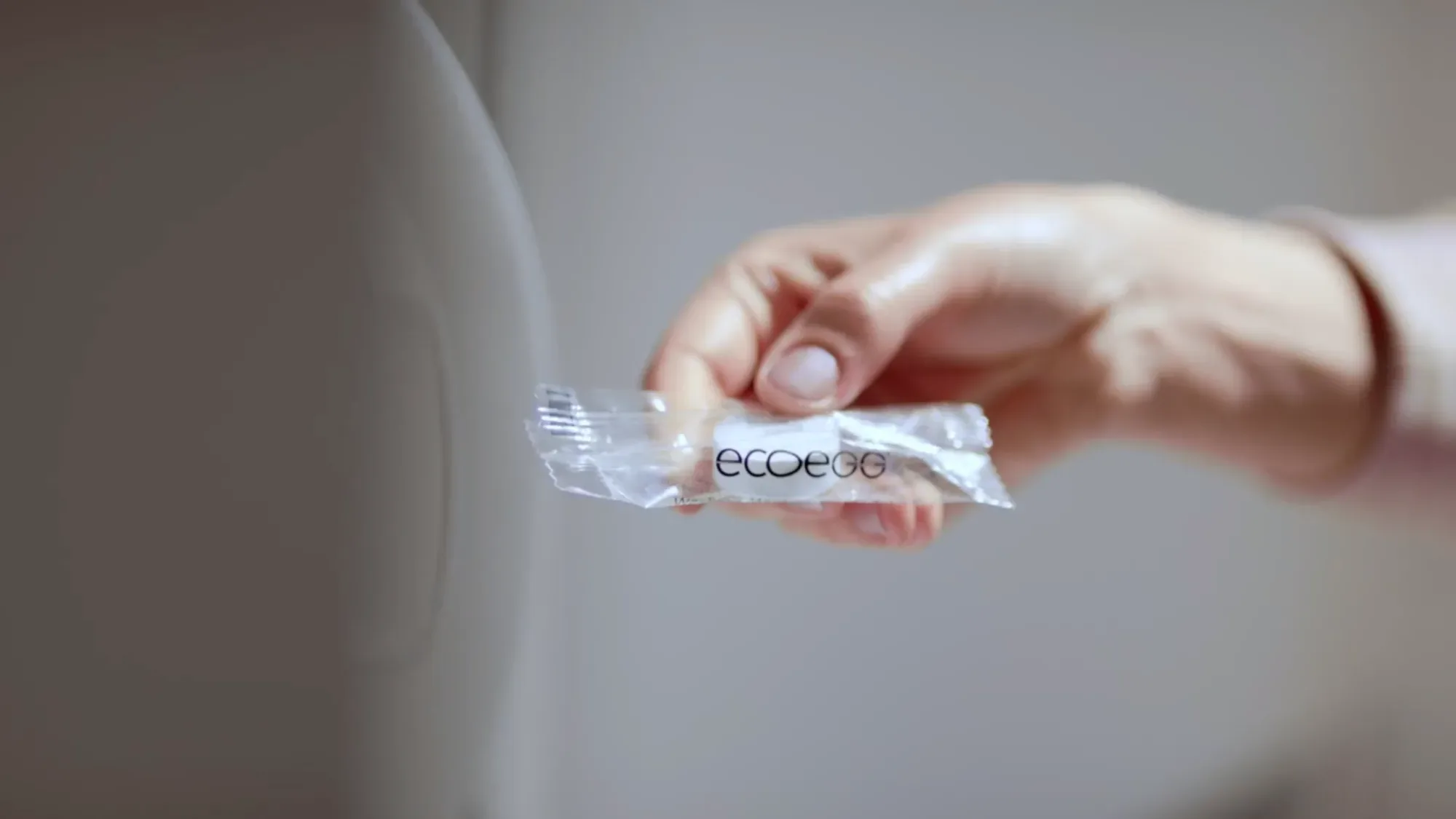 A hand holds a small EcoEgg product refill in clear packaging, filmed by Floating Harbour for a brand film and supporting web content.
